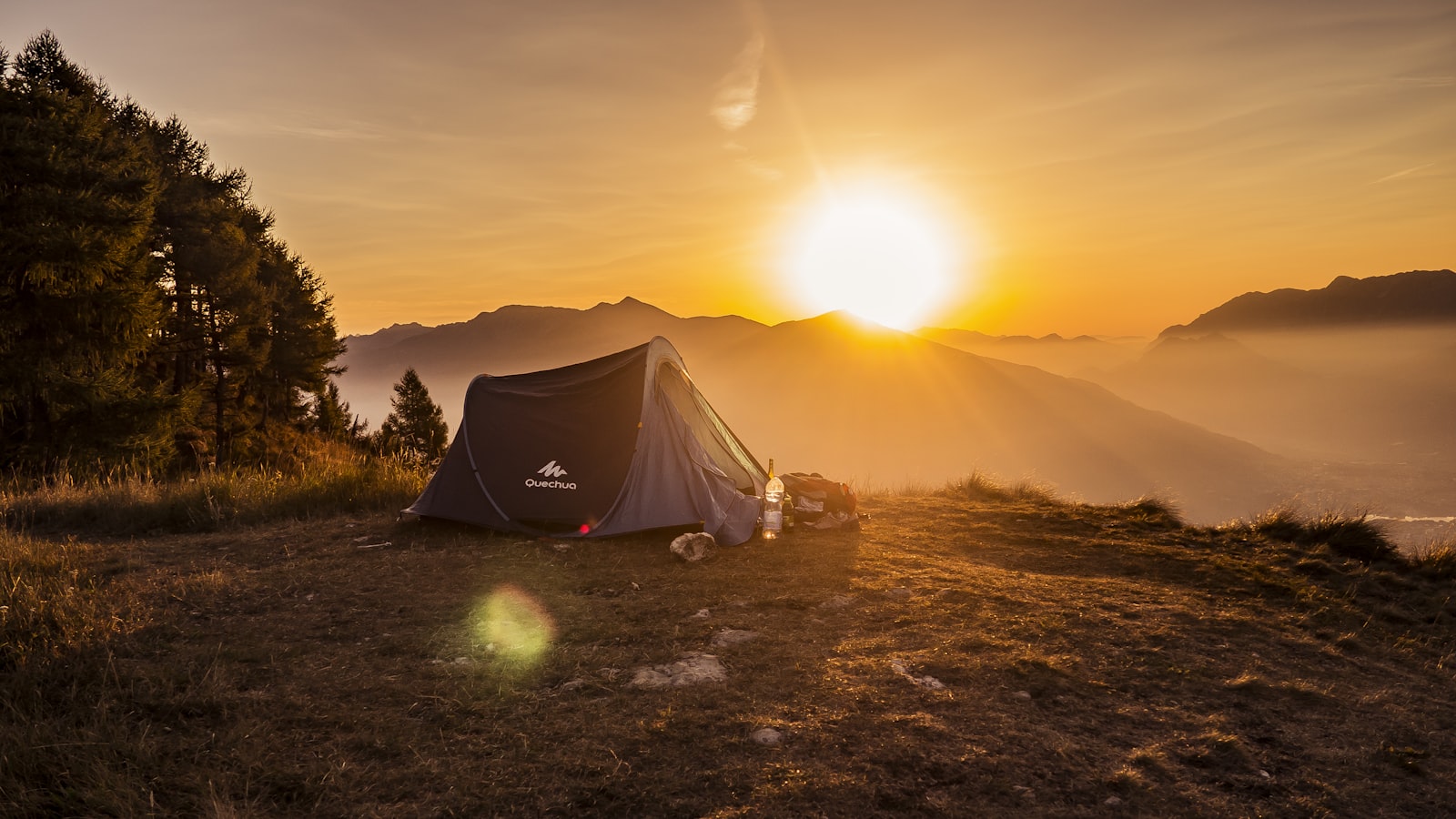 Camping gear laid out neatly on the ground including tent, pack, and cookware