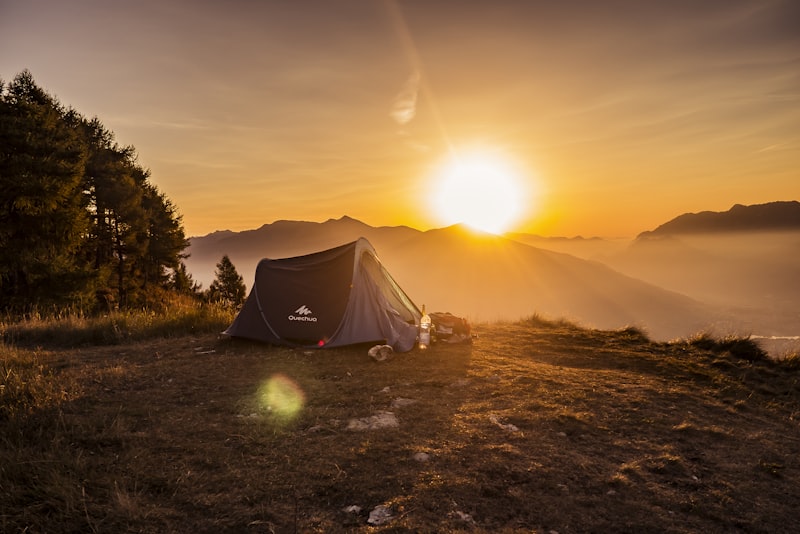 Camping gear laid out neatly on the ground including tent, pack, and cookware